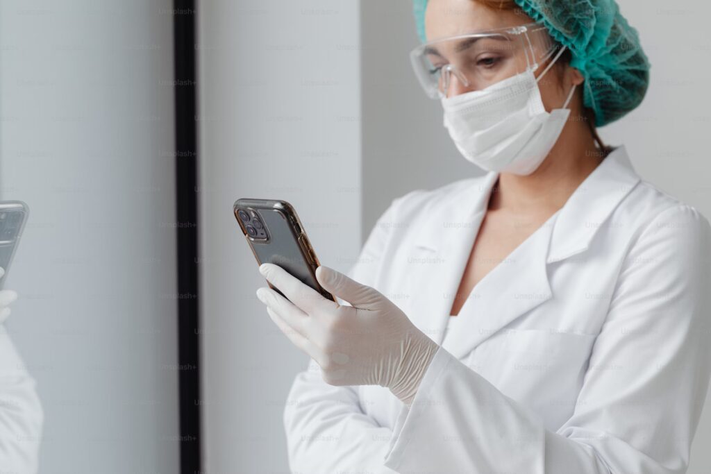 Nurse in white clothes looking at her smartphone